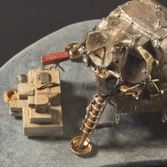 “Complete Apollo lunar mission diorama featuring painted and weathered lunar lander, rover, astronauts, tools, and flag displayed on a sculpted lunar base.”